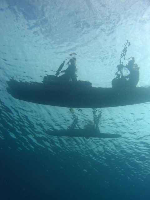 Outrigger canoe as seen from below passing over dive team Picture