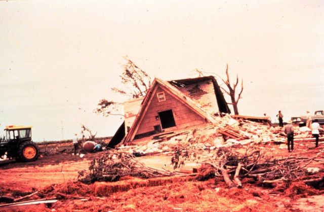 Neighbors and friends work to remove debris around remains of a farmhouse Picture