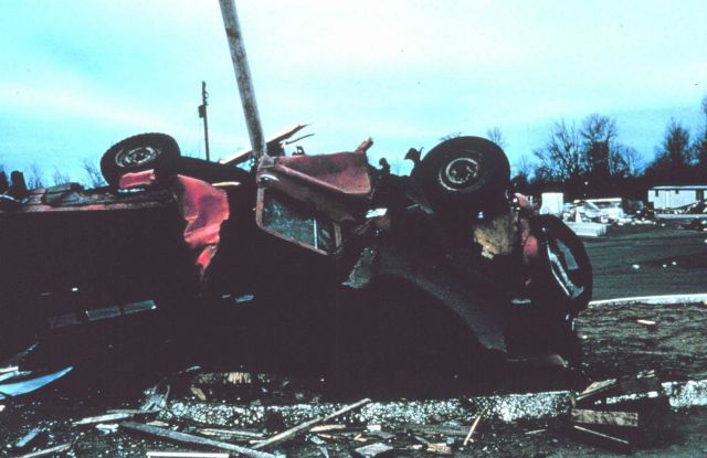 Tornado crushes and rolls farm vehicle, pinning it against a post. Picture