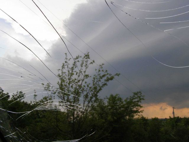 VORTEX2 tornado investigators peering through a windshield cracked by hail. Picture
