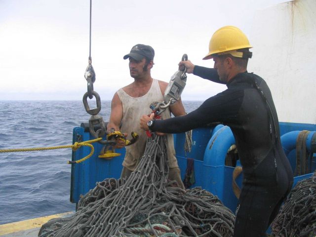 Preparing to weight derelict net that had just been lifted onto the CASITAS. Picture