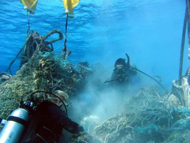 Cutting large pile of derelict net material Picture
