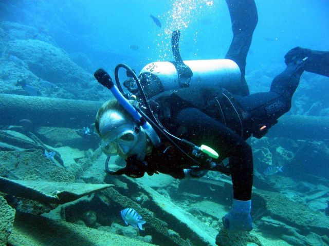 Diver inspecting modern ship wreck on Pearl and Hermes Reef. Picture