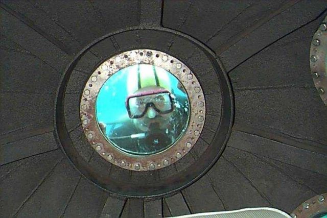 Diver peering through viewing port of DAVID STARR JORDAN. Picture