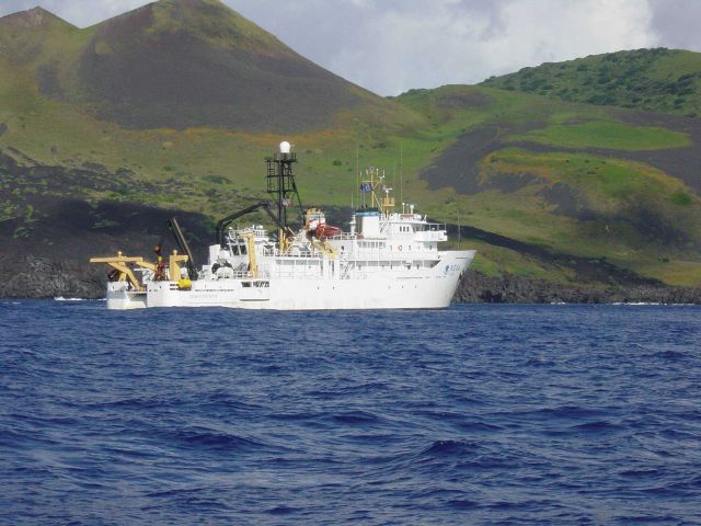 NOAA Ship OSCAR ELTON SETTE at anchor off a volcanic island. Picture