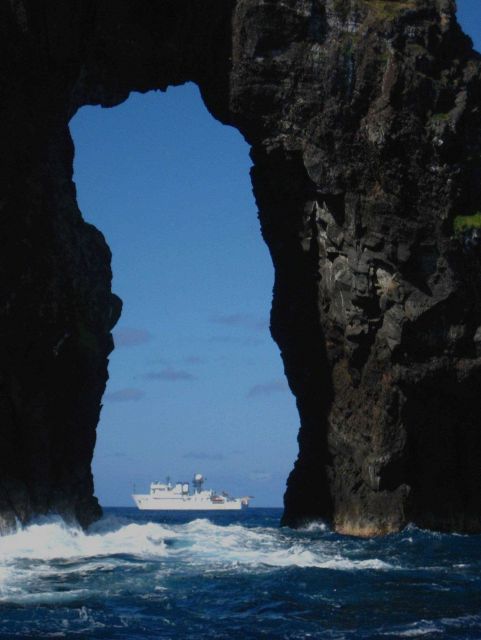 NOAA Ship HI'IALAKAI seen offshore through natural arch at Pagan Island. Picture