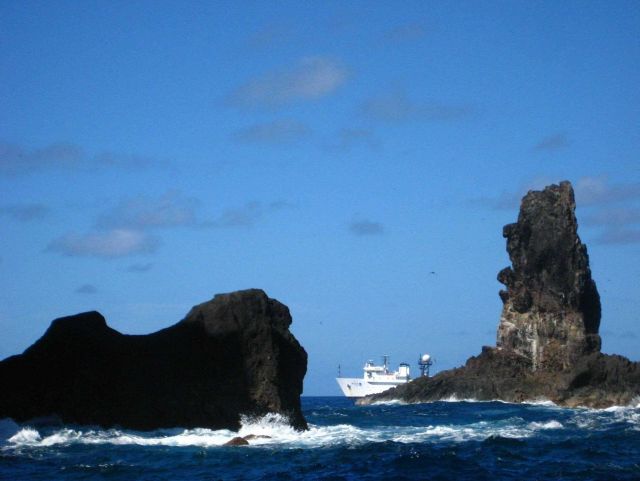 NOAA Ship HI'IALAKAI seen offshore through natural arch at Pagan Island. Picture
