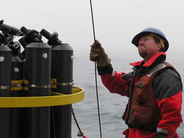 Deploying a CTD rosette with water sampling bottles Picture