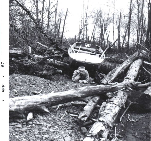 Fisheries researchers dragging boat over log jam on Pacific Northwest salmon stream. Picture
