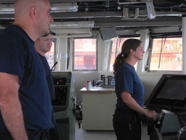 Commander Jeremy Adams on the left, commanding officer of the NOAA Ship PISCES, monitoring its transit through the many ships and other craft on-site  Picture