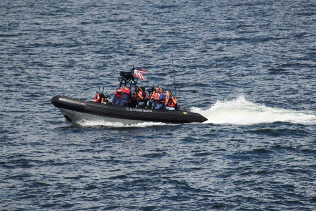 United States Coast Guard rigid-hull inflatable boat underway with passengers. Picture