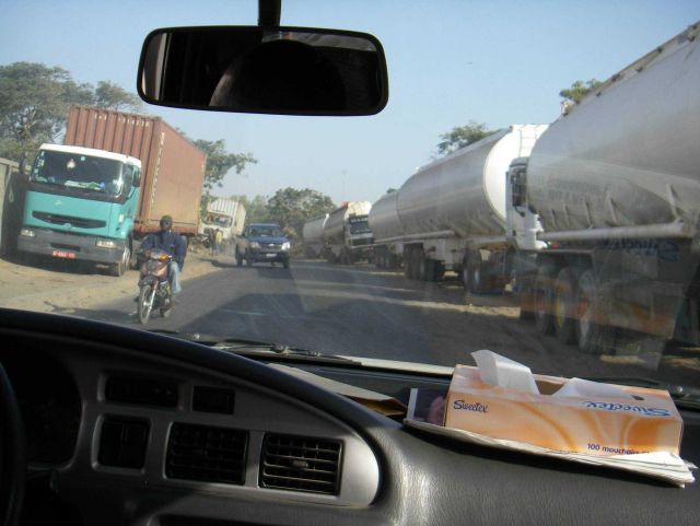 Competing for space on a Dakar street with tank trucks, motorcycles, and passenger vehicles. Picture