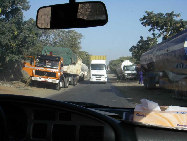 Competing for space on a Dakar street with tank trucks, motorcycles, and semi-trucks. Picture