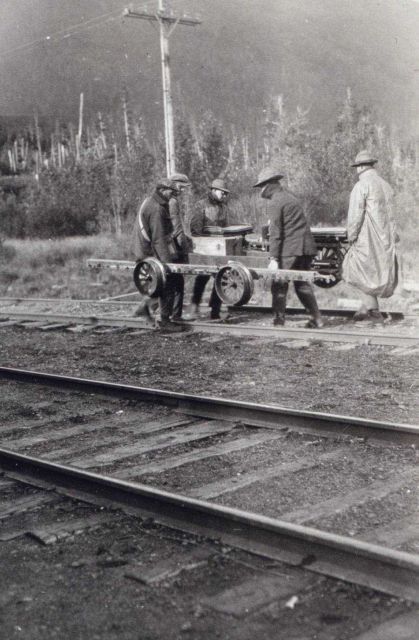 Leveling crew moving velocipede off tracks for approaching train Picture