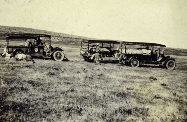 Two trucks pulling a third from a mudhole Picture