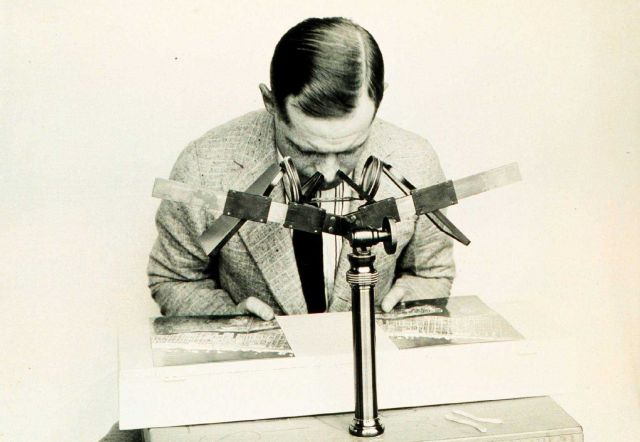 Using a stereoscope to bring images on adjacent photographs into coincidence. Picture