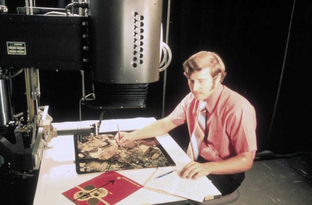 Photogrammetrist compiling chart from aerial photographs. Picture