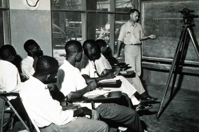 Commander George Morris instructing Liberian engineering students in the use of surveying instruments. Picture