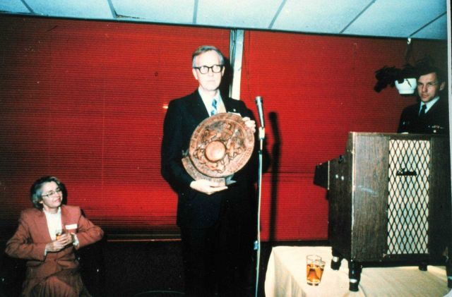 Rear Admiral Harley Nygren holding NOAA Corps insignia plaque presented to him on the occasion of his retirement. Picture