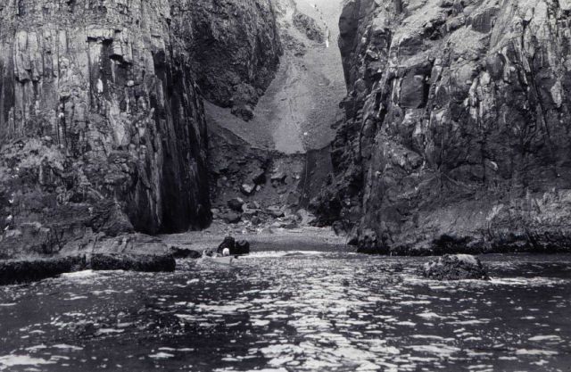 Carrying lumber up rift in cliffs at east end of Amlia Island Picture
