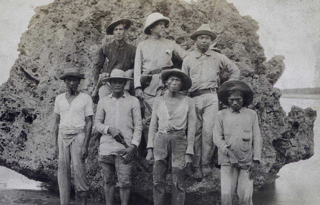 Shore camp crew posing on coral rock. Picture