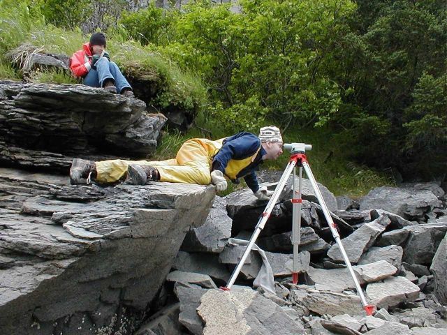 Using a little extra body english to get that observation during tidal bench mark leveling operations on a rocky shore. Picture