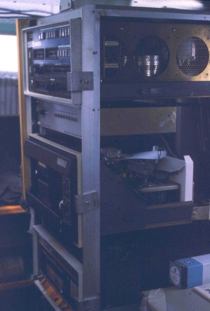 Hydroplot data acquisition system with controller on top paper tape reader and data punch middle lower unit, and PDP-8 computer with orange and yellow Picture