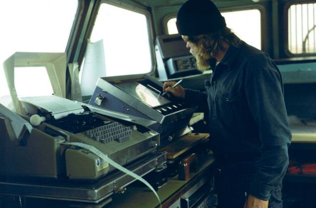 Survey technician annotating echo-sounder record on FAIRWEATHER hydrographic survey launch. Picture