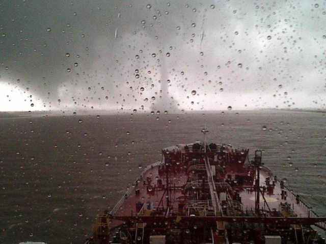 Tornadic waterspout crossing Mississippi River in front of large moving ship on the Mississippi River Picture