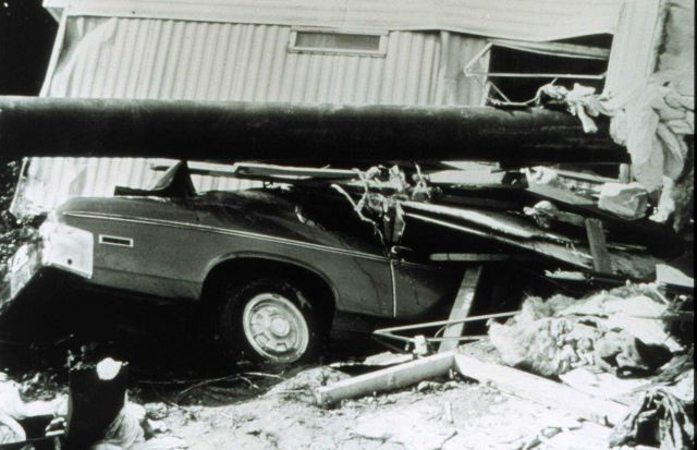 Trailer, vehicle, and utility pole in jumbled pile following a flash flood Picture