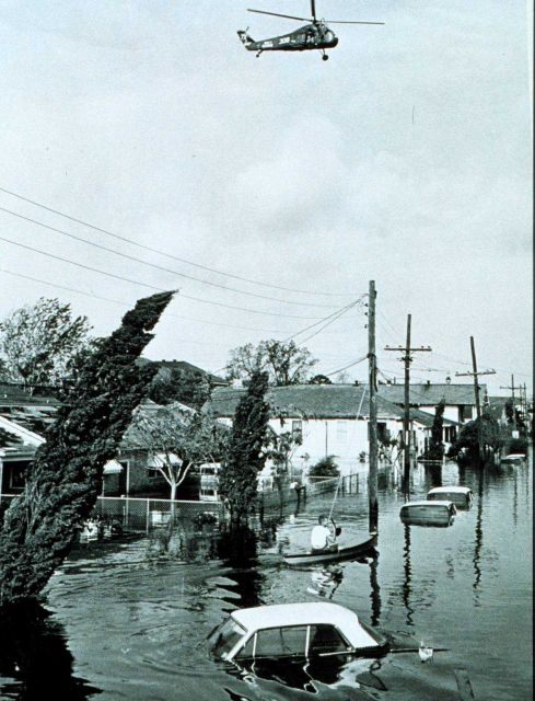 Helicopter hovers over flooded area following passage of Hurricane Betsy 164,000 homes were flooded in this storm Small loss of life as residents heed Picture