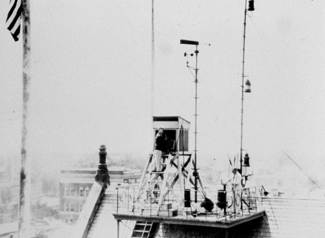 Meteorologist reading temperature on top of Weather Bureau facility Picture