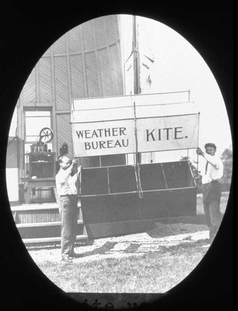 Kite being prepared for launching with kite-reel house in the background Picture