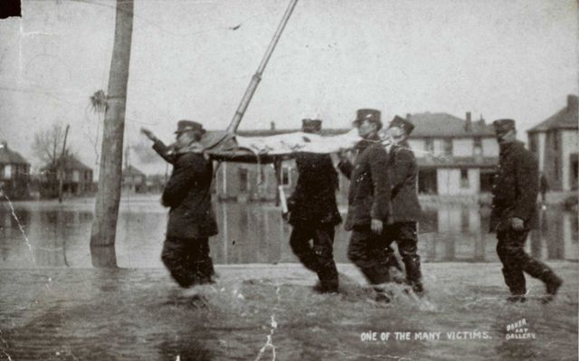 Police carrying a victim of the 1913 flooding. Picture