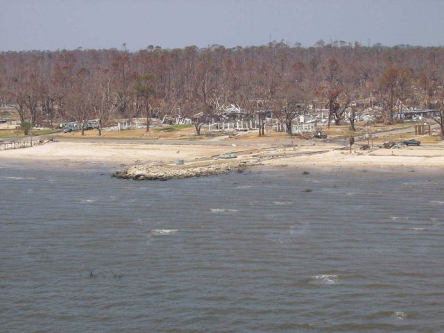 Veteran's memorial with destroyed homes in background Picture