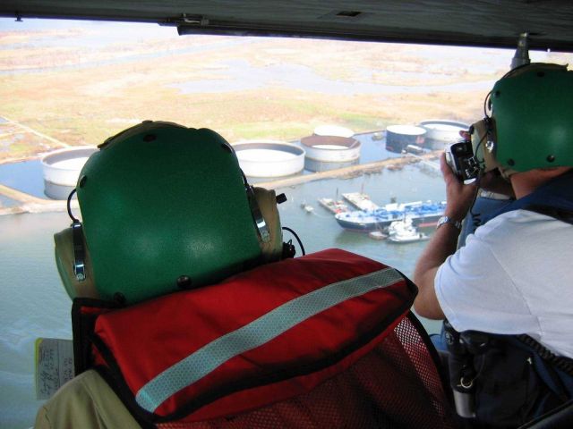 Cataloging damage to oil storage facility near mouth of Mississippi River. Picture