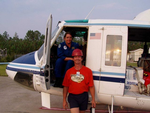 NOAA Corps woman helicopter pilot and civilian flying in support Hurricane Katrina damage evaluation and relief efforts. Picture