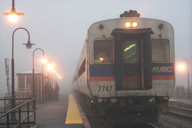 MARC commuter train conductor catching up with local news on a foggy morning at Brunswick, MD. Picture
