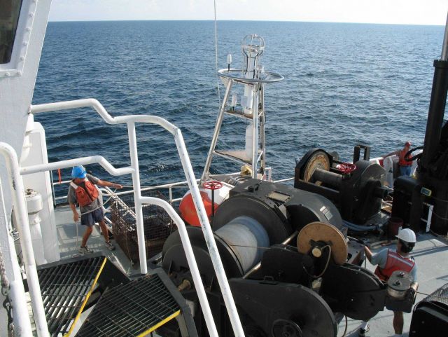 While the clouds approach and the TAO buoy streams aft with attached line, the deck crew of the NOAA Ship GORDON GUNTER move a second TAO to its pre-m Picture