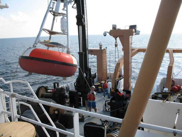 While the clouds approach and the TAO buoy streams aft with attached line, the deck crew of the NOAA Ship GORDON GUNTER move a second TAO to its pre-m Picture