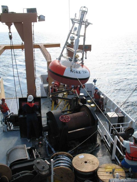 While the clouds approach and the TAO buoy streams aft with attached line, the deck crew of the NOAA Ship GORDON GUNTER move a second TAO to its pre-m Picture
