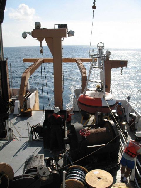 While the clouds approach and the TAO buoy streams aft with attached line, the deck crew of the NOAA Ship GORDON GUNTER move a second TAO to its pre-m Picture