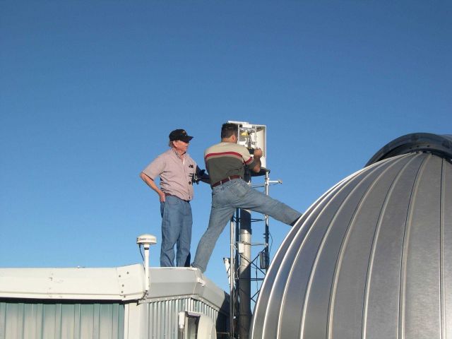 Scientists repair an instrument adjacent to a dome that houses an ultraviolet spectroradiometer at NOAA's Mauna Loa Observatory. Picture