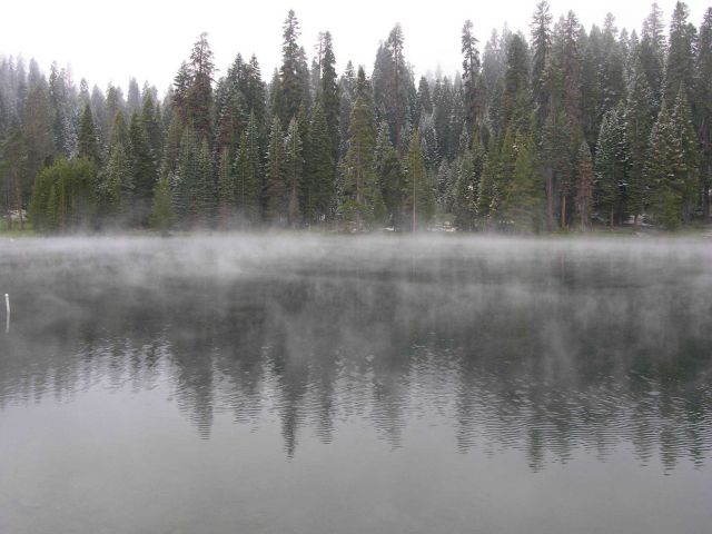 A dusting of snow with cold air over warmer water in a lake causing fog to form. Picture