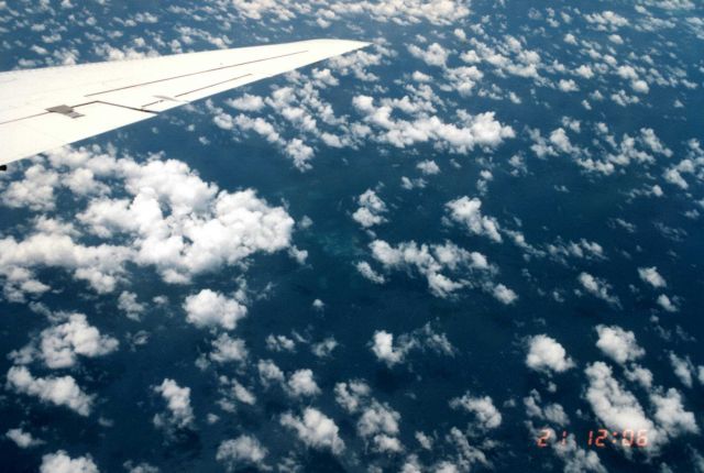 Right wing of NASA DC-8 with puffy fair weather cumulus and hints of reefs seen below Picture