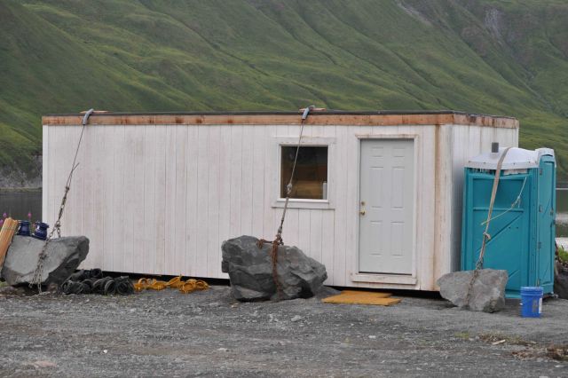 Trailer anchored with boulders to prevent blowing away during williwaws. Picture