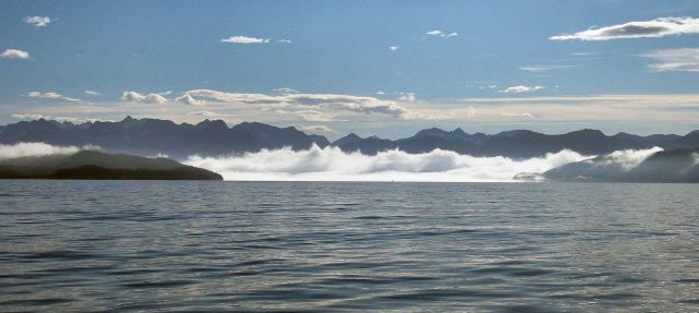 Clear offshore, fog nearshore in Prince William sound as the sun climbs higher in the sky. Picture