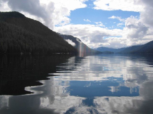 Cumulus clouds reflecting on the water of an Alaskan Bay. Picture