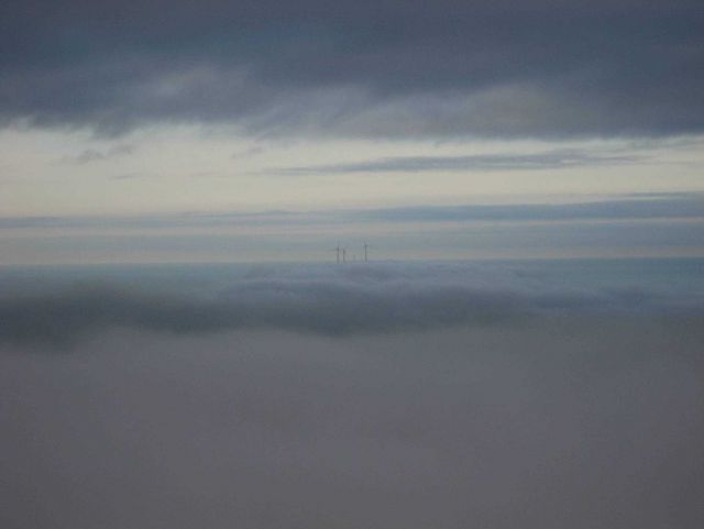 The windmills of Kodiak Island standing above the clouds. Picture