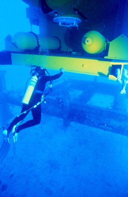Divers guide the 15 meter long AQUARIUS onto the baseplate. Picture